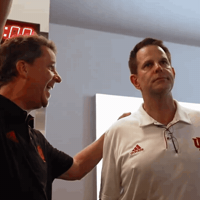 A Man Wearing An Adidas Shirt Stands Next To A Man Wearing A Black Shirt GIF