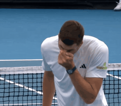 A Man Wearing An Adidas Shirt Wipes His Nose With His Hand GIF