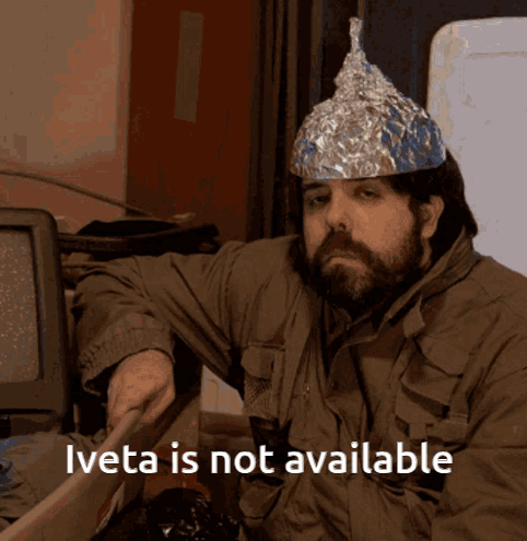 A Man Wearing An Aluminum Foil Hat With The Words Iveta Is Not Available Below Him GIF