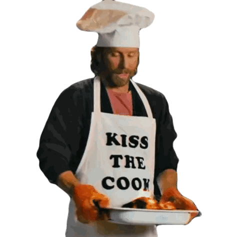 A Man Wearing An Apron That Says Kiss The Cook Holds A Pan Of Food Sticker