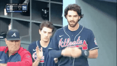 A Man Wearing An Atlanta Braves Jersey Stands In Front Of A Man Wearing An A Hat GIF