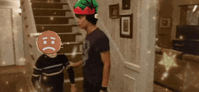 A Man Wearing An Elf Hat Is Talking To A Boy With A Sad Face GIF