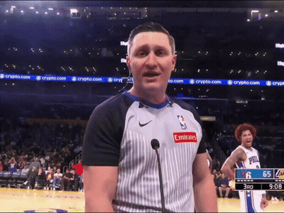A Man Wearing An Emirates Shirt Stands In Front Of A Microphone On A Basketball Court GIF