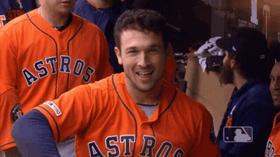 A Man Wearing An Orange Astros Jersey Smiles For The Camera GIF