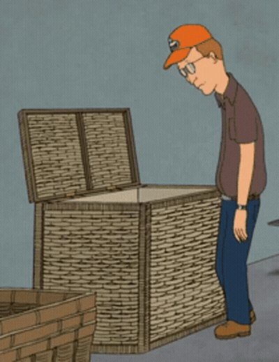 A Man Wearing An Orange Hat Is Looking Into A Wicker Box GIF