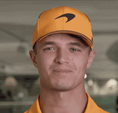 A Man Wearing An Orange Hat With A Mclaren Logo GIF