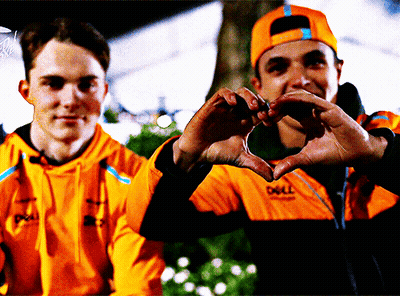 A Man Wearing An Orange Jacket That Says Dell Makes A Heart Shape With His Hands GIF