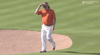 A Man Wearing An Orange Shirt And White Pants Is Walking On A Golf Course Sponsored By The European Tour GIF