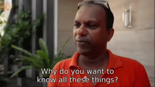A Man Wearing An Orange Shirt Is Asking Why Do You Want To Know All These Things GIF