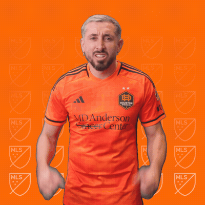 A Man Wearing An Orange Shirt That Says Manderson Soccer Center Holds His Fist In The Air GIF