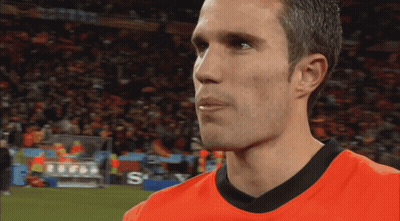 A Man Wearing An Orange Shirt With The Letter S On The Bottom Right GIF