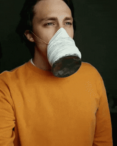 A Man Wearing An Orange Sweater And A White Mask GIF
