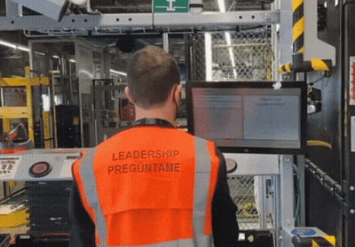 A Man Wearing An Orange Vest With Leadership Preguntame On It GIF