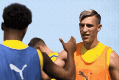 A Man Wearing An Orange Vest With The Letter Y On The Back GIF