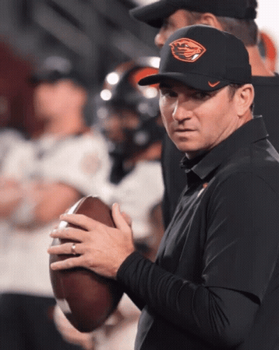 A Man Wearing An Oregon Hat Holds A Football In His Hands GIF
