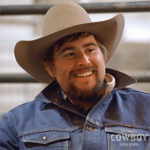 A Man Wearing An Ultimate Cowboy Showdown Jacket And Cowboy Hat GIF
