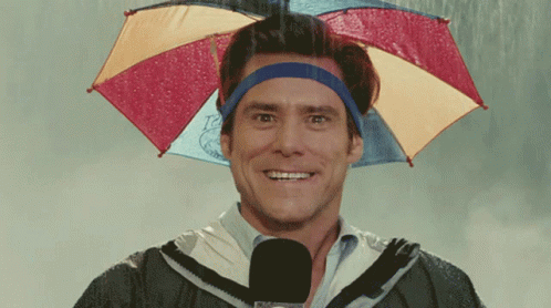 A Man Wearing An Umbrella On His Head Is Smiling In The Rain GIF