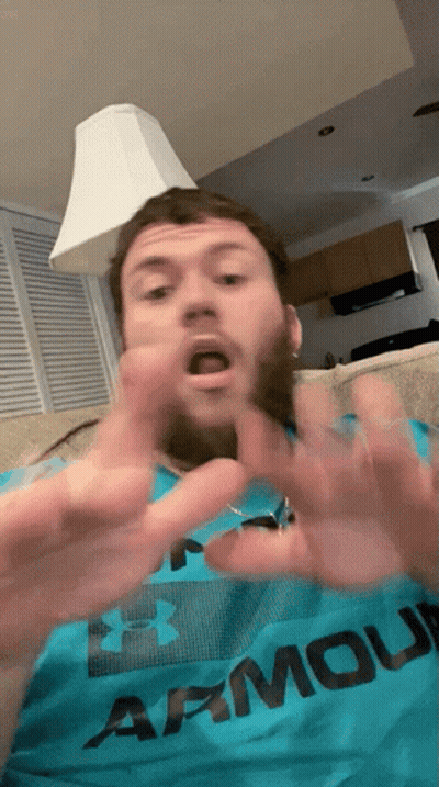 A Man Wearing An Under Armour Shirt Is Making A Funny Face GIF