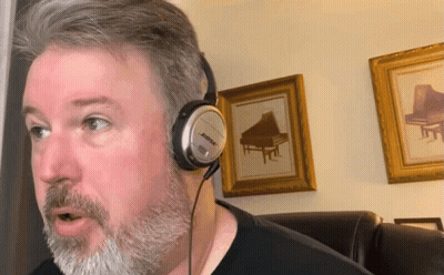 A Man Wearing Bose Headphones Is Talking GIF