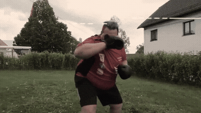 A Man Wearing Boxing Gloves And A Red Shirt That Says ' Team ' On It GIF