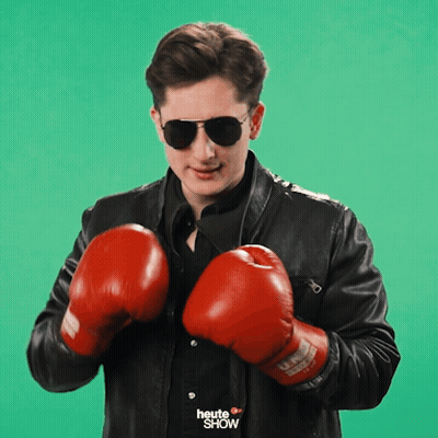 A Man Wearing Boxing Gloves And Sunglasses With The Word Heute Show On His Shirt GIF