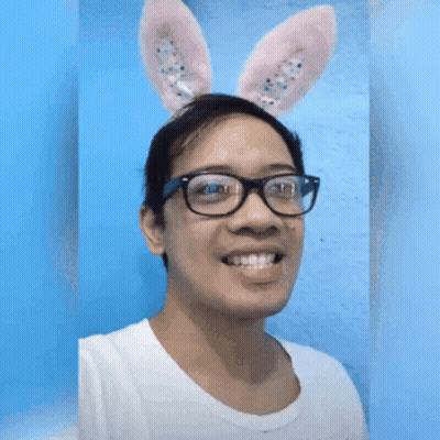 A Man Wearing Bunny Ears And Glasses Is Making A Funny Face GIF