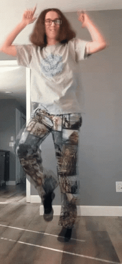 A Man Wearing Camo Pants Is Jumping In The Air With His Hands In The Air GIF