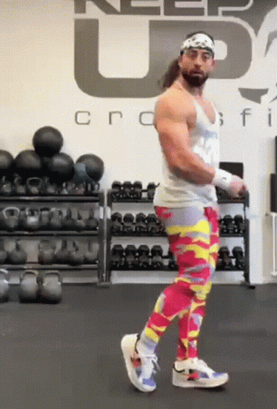 A Man Wearing Colorful Pants Is Standing In A Gym . GIF