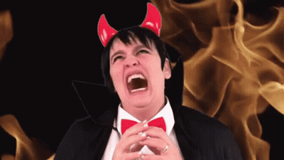 A Man Wearing Devil Horns And A Black Cape Screams GIF