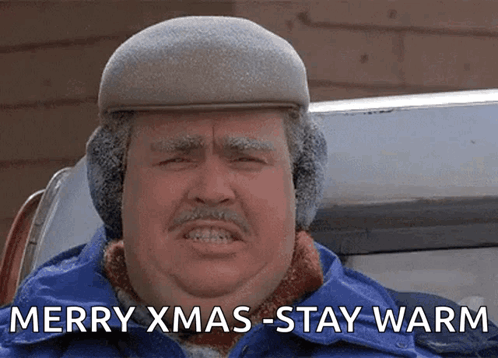 A Man Wearing Ear Warmers And A Hat Says Merry Xmas-Stay Warm GIF