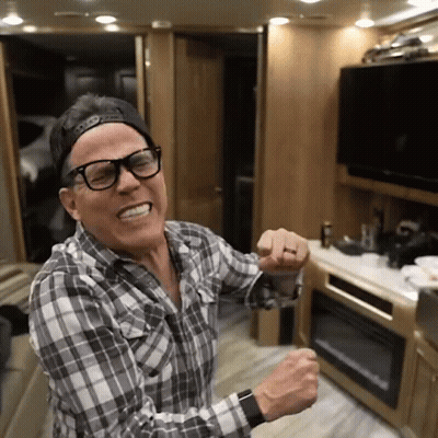 A Man Wearing Glasses And A Baseball Cap Is Dancing In A Kitchen GIF