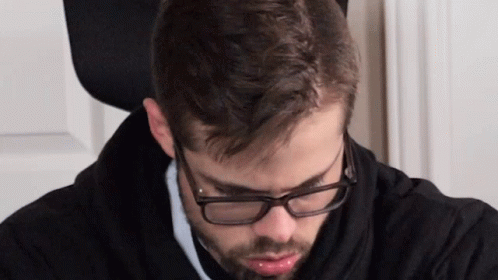 Man In Glasses And Black Hoodie Looking Down GIF