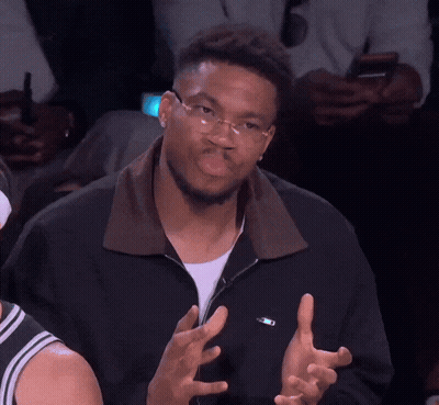 A Man Wearing Glasses And A Black Jacket Has His Hands Up GIF