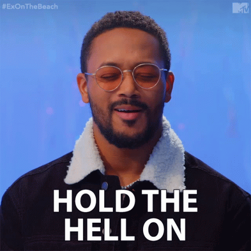 A Man Wearing Glasses And A Black Jacket Says " Hold The Hell On " GIF