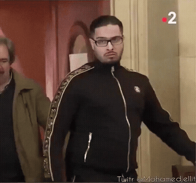 A Man Wearing Glasses And A Black Jacket With The Number 2 In The Corner GIF