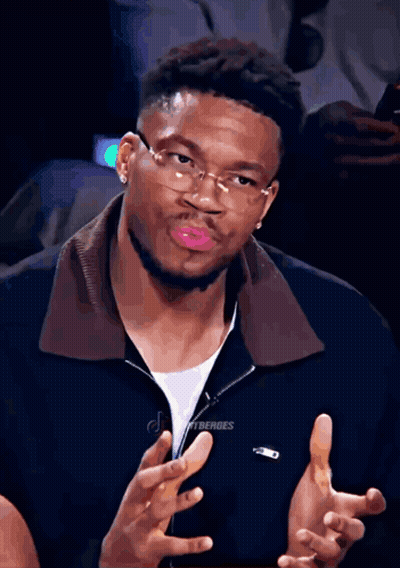 A Man Wearing Glasses And A Black Jacket With The Word Lacoste On It GIF