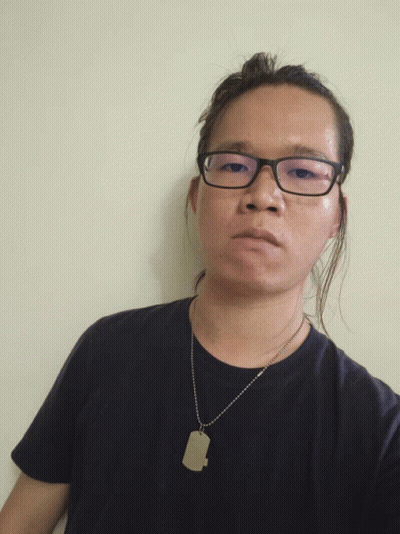 A Man Wearing Glasses And A Black Shirt Has A Dog Tag Necklace Around His Neck GIF