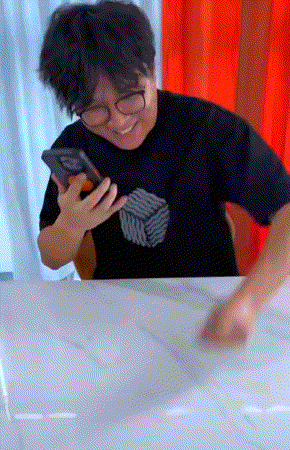 A Man Wearing Glasses And A Black Shirt Holds A Cell Phone In His Hand GIF