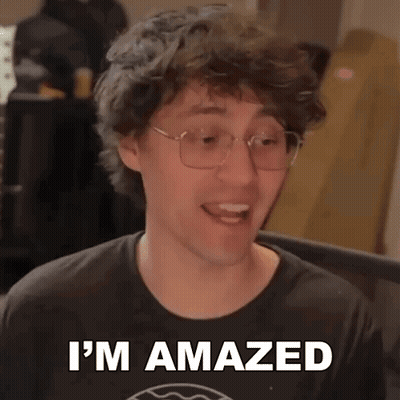 A Man Wearing Glasses And A Black Shirt Is Making A Funny Face And Saying I 'M Amazed . GIF