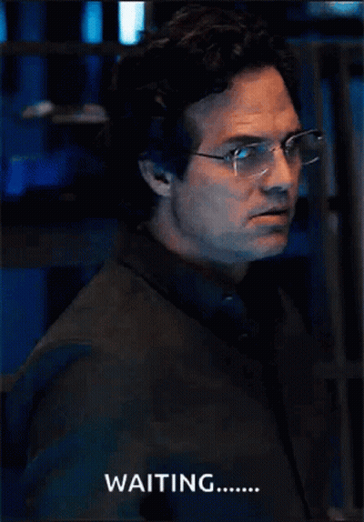 A Man Wearing Glasses And A Black Shirt Says Waiting GIF
