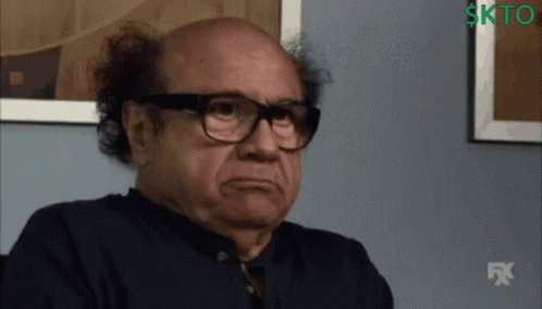 A Man Wearing Glasses And A Black Shirt With A Fx Logo In The Background GIF
