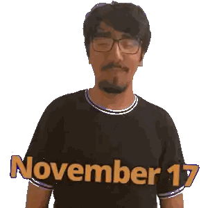 A Man Wearing Glasses And A Black Shirt With November 17 Written On It Sticker