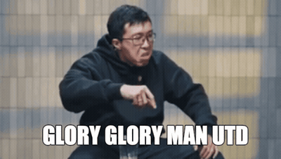 A Man Wearing Glasses And A Black Sweatshirt Says Glory Glory Man Utd In White Letters GIF