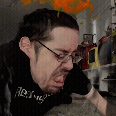 A Man Wearing Glasses And A Black T-Shirt That Says ' Rage ' On It GIF
