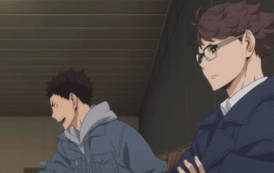 A Man Wearing Glasses And A Blue Jacket Is Standing Next To Another Man GIF