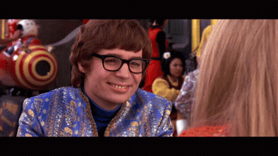 A Man Wearing Glasses And A Blue Jacket Smiles GIF