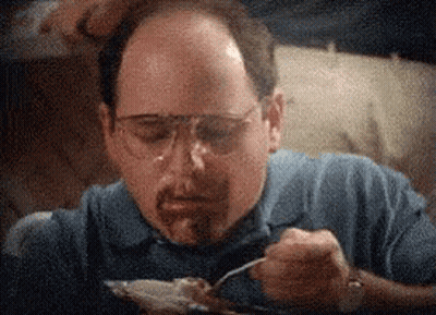 A Man Wearing Glasses And A Blue Shirt Is Eating Food With A Fork . GIF