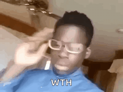 A Man Wearing Glasses And A Blue Shirt Is Holding A Fork To His Ear . GIF