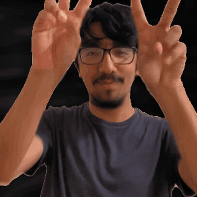 A Man Wearing Glasses And A Blue Shirt Is Making A Peace Sign GIF