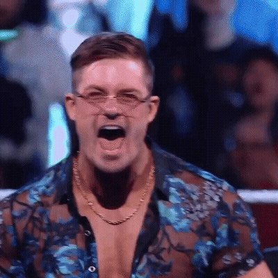 A Man Wearing Glasses And A Blue Shirt Is Screaming In A Ring . GIF